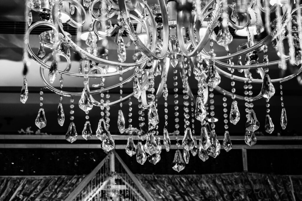 A stunning black and white image of a luxurious crystal chandelier with intricate design details.